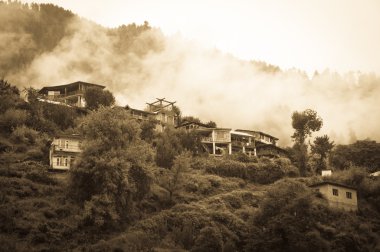 Houses in mountains covered by clouds and rain clipart