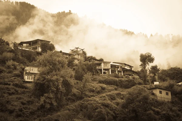 Casas em montanhas cobertas por nuvens e chuva — Fotografia de Stock