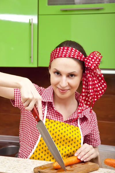 Woman in the kitchen with knife and vegetables — Stock Photo, Image