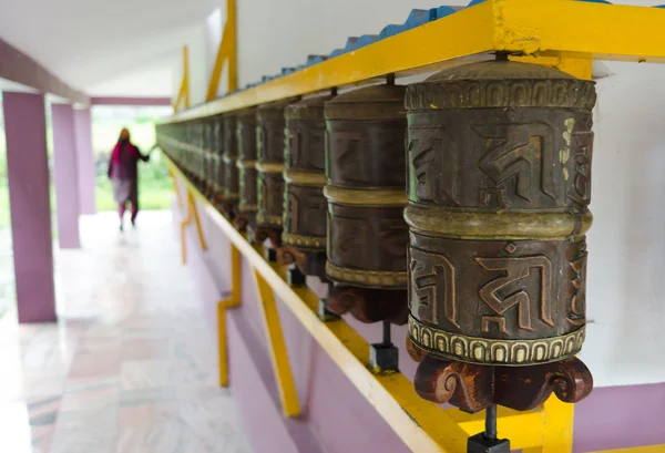 Woman and prayer wheels in a row — Stock Photo, Image