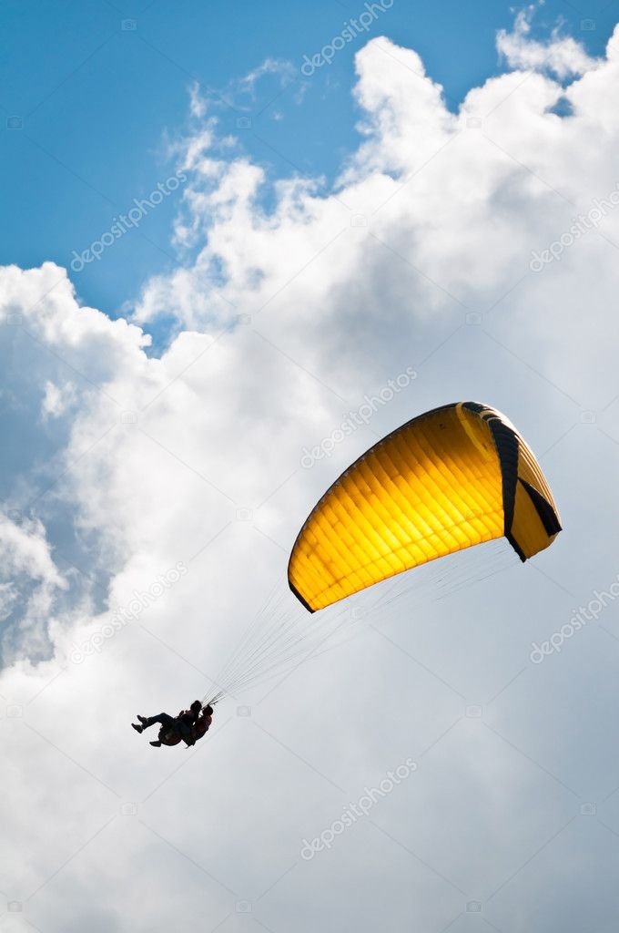 Yellow parachute against sky and clouds