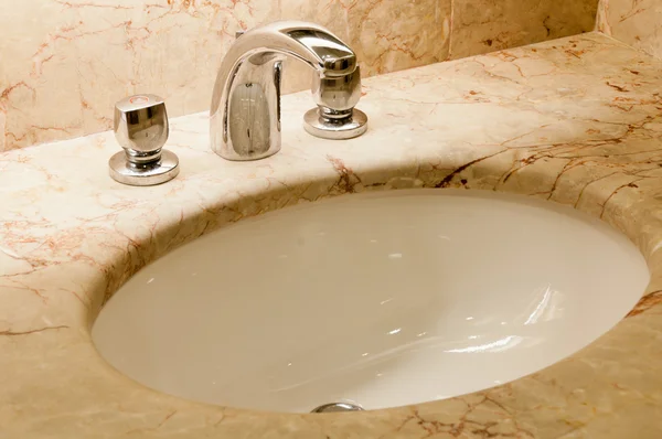 Robinet avec poignées et lavabo blanc — Photo