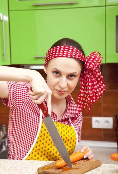 Frau in der Küche mit Messer und Gemüse — Stockfoto