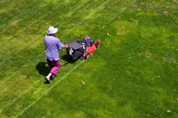 Erkek bahçıvan çim biçme makinesi ile çalışma — Stok fotoğraf