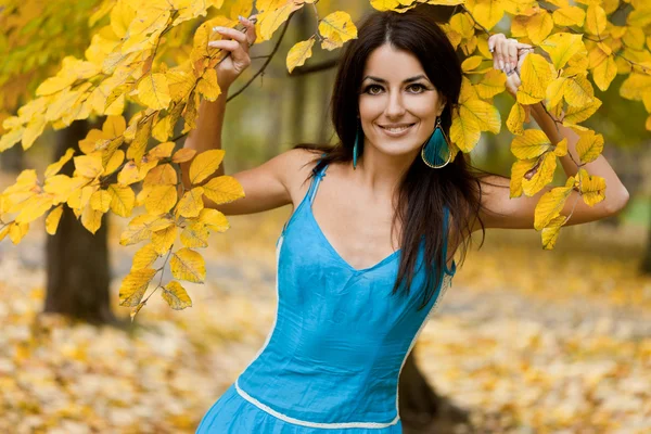 Woman with yellow leaves in autumn — Stock Photo, Image