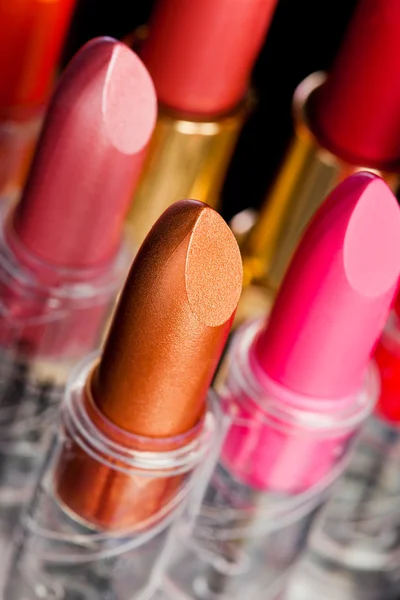 Many lipsticks on black background — Stock Photo, Image