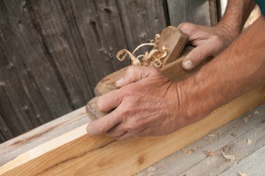 Hands of a carpenter planed wood clipart