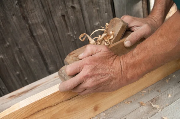 Χέρια ενός ξυλουργού πλανισμένη ξυλεία — Φωτογραφία Αρχείου