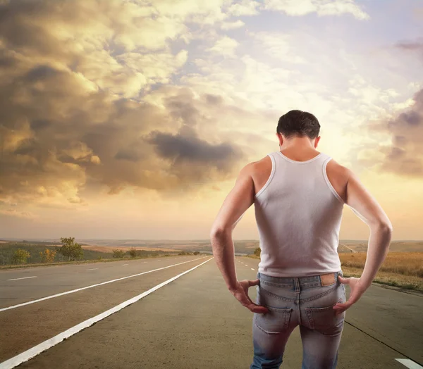 Homem musculoso em pé na estrada — Fotografia de Stock