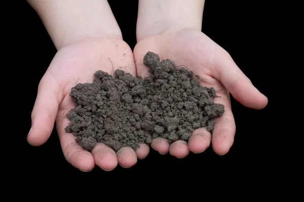 Черная почва в руках женщины — стоковое фото