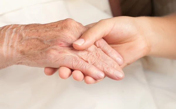 Helpen de senior, die hand — Stockfoto