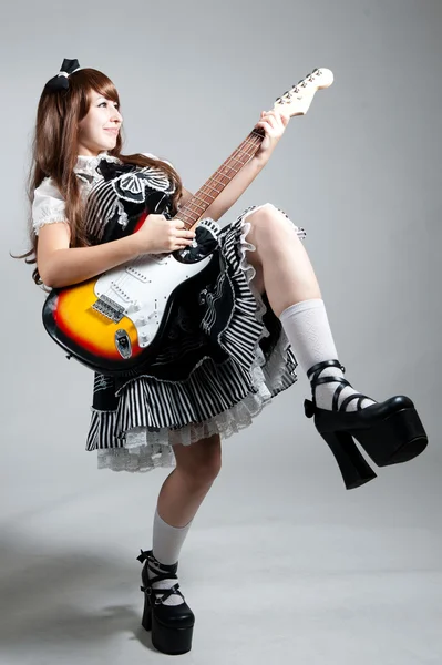 Cosplay meisje in zwarte jurk met gitaar — Stockfoto