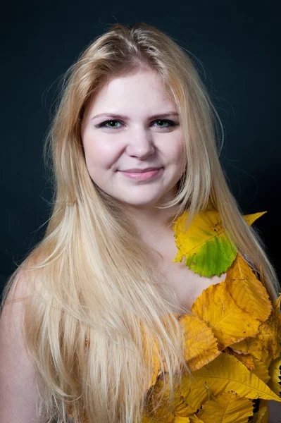 Porträt Mädchen im Kleid mit Herbstblättern dekoriert — Stockfoto