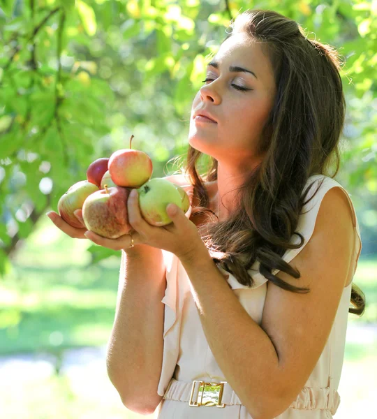 Beautiful young girl with apples in summer park enjoying — Stock Photo, Image