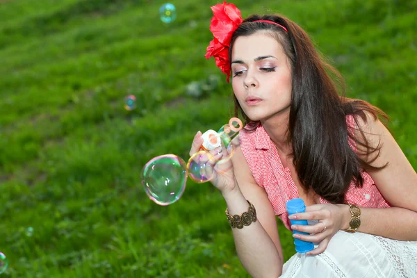 Привлекательная молодая девушка с мыльными пузырями — стоковое фото