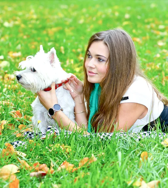 Portret van mooi meisje met haar hond liggend — Stockfoto