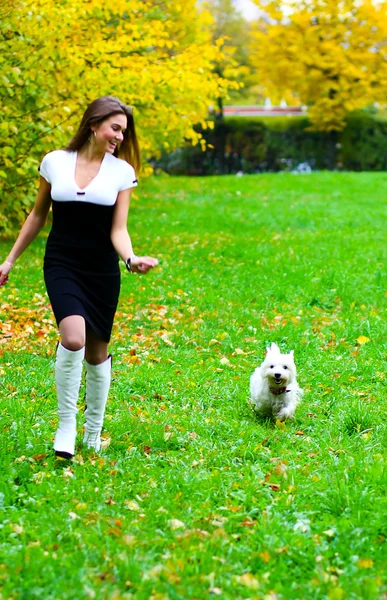 Chica joven corriendo con su perro — Foto de Stock