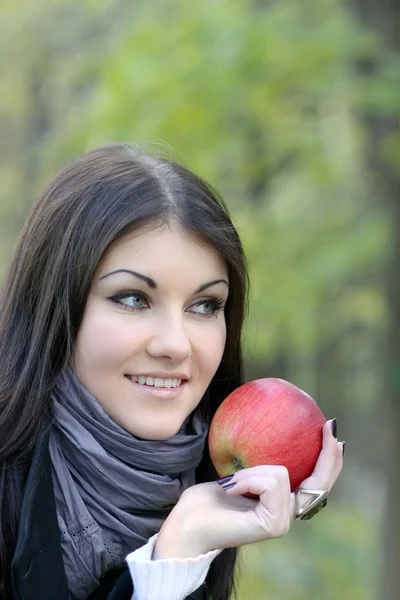 Portrait of the beauty girl with red color apple in park — Stock Photo, Image