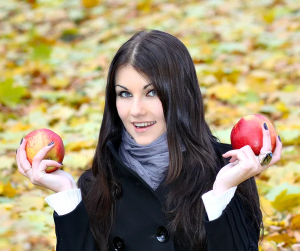 Retrato da mulher linda hesitou com duas maçãs vermelhas frescas brilhantes — Fotografia de Stock