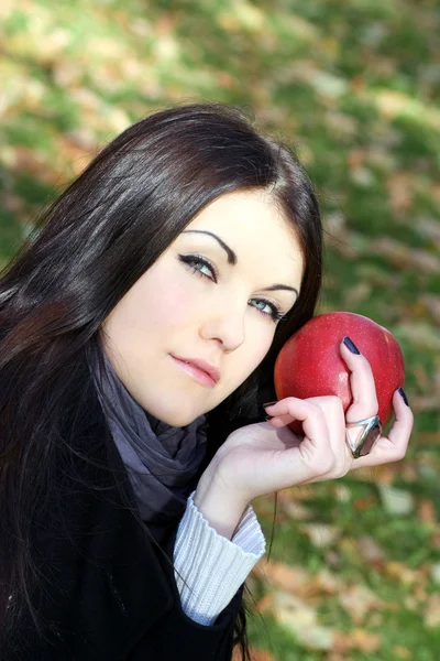 Retrato de la chica de belleza con manzana de color rojo en el parque — Foto de Stock