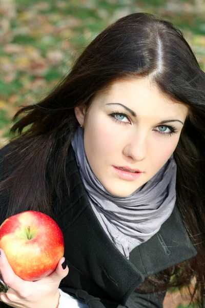 Ritratto della bella ragazza con mela di colore rosso nel parco — Foto Stock