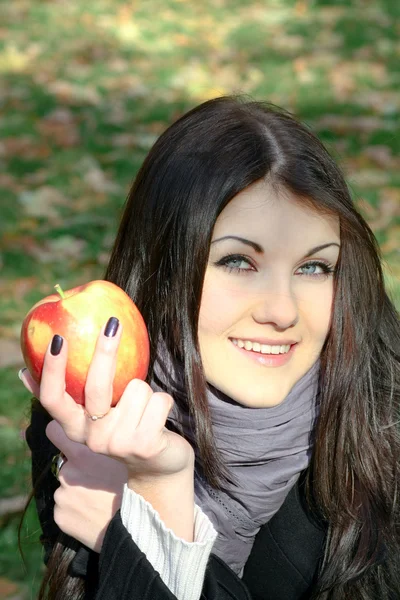 Portrait of the beauty girl with red color apple in park — Stock Photo, Image