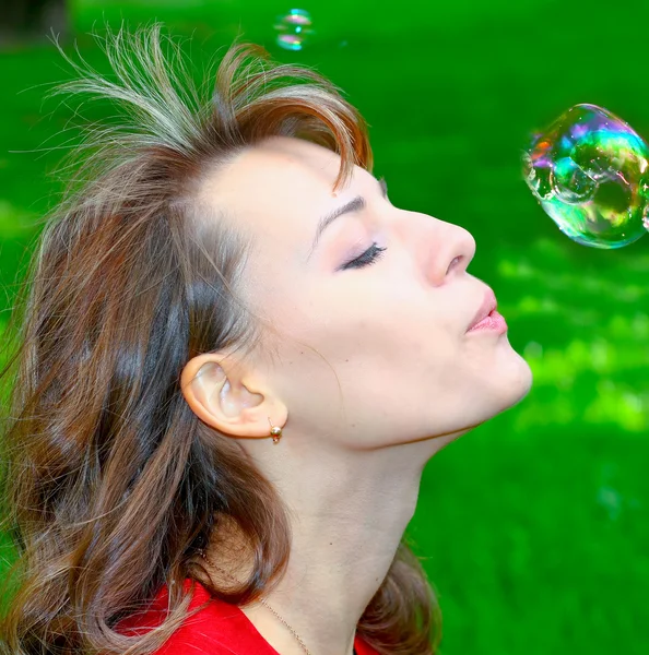 Porträt eines atemberaubenden Mädchens, das Seifenblasen aufbläst — Stockfoto