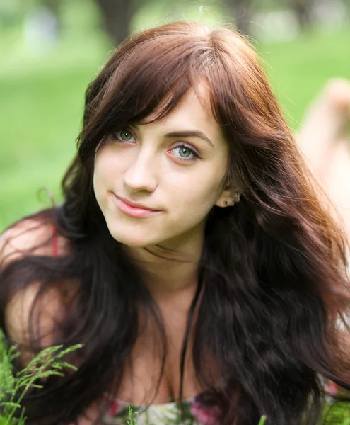 Porträtt av vacker ung kvinna avkopplande i sommaren park — Stockfoto