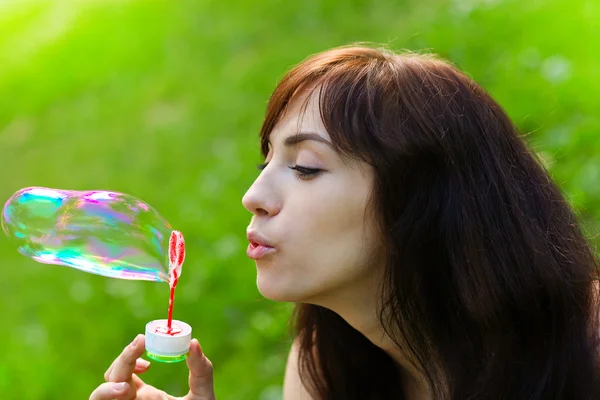 Porträt eines attraktiven jungen Mädchens, das bunte Seifenblase aufbläst — Stockfoto