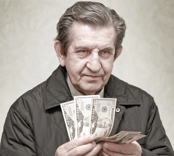 Пожилой счастливый человек с пачкой денег — стоковое фото