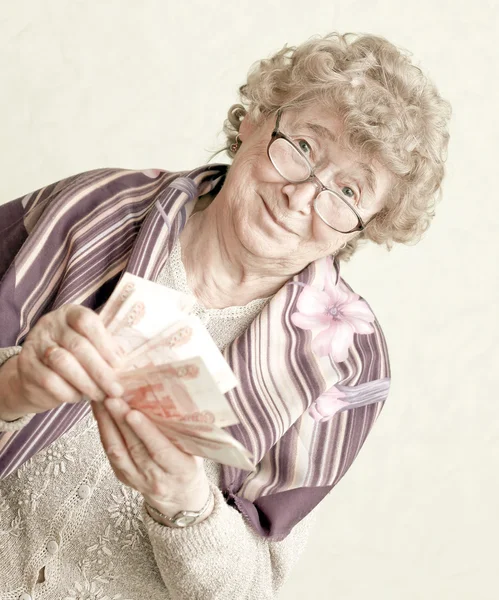 Пожилая счастливая женщина с пачкой денег — стоковое фото