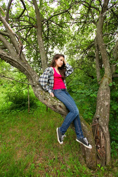 Όμορφη κοπέλα στο πυκνό δάσος κάθονται στα κλαδιά — Φωτογραφία Αρχείου