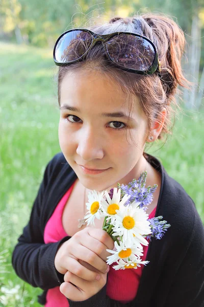 Gelukkig jong meisje met brigth bloemen in mooie bos — Stockfoto