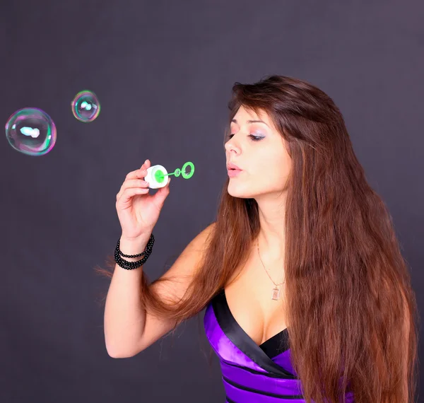 Portrait of funny lovely teenage girl inflating colorful soap bu — Stock Photo, Image