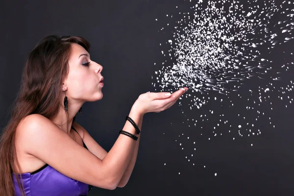 Portrait of funny lovely teenage girl inflating snowflakes, studio shot — Stock Photo, Image