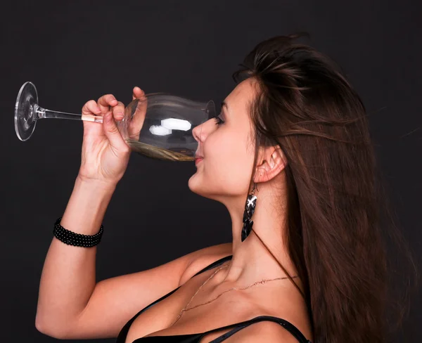 Retrato de una hermosa chica morena bebiendo champán del vino —  Fotos de Stock