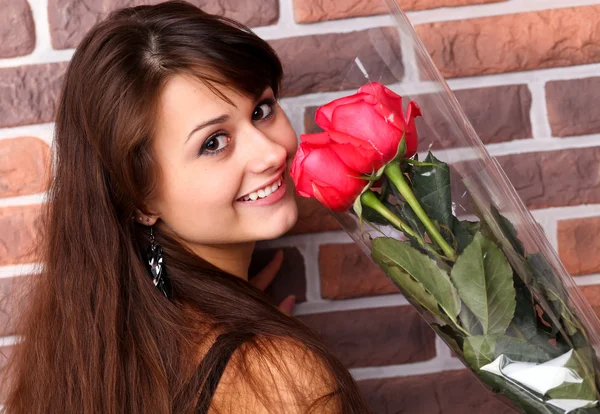 Romantic portrait of a pretty teenage girl with a gorgeous bouquet of red r — Stock Photo, Image