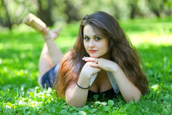 Portrét krásné mladé ženy relaxační v letním parku — Stock fotografie