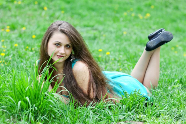 Bonito jovem alegre menina escondendo-se atrás brilhante verde lâminas de g — Fotografia de Stock