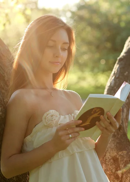 Muotokuva houkutteleva nuori tyttö käsittelyssä kirja kauniissa auringonpaisteessa — kuvapankkivalokuva