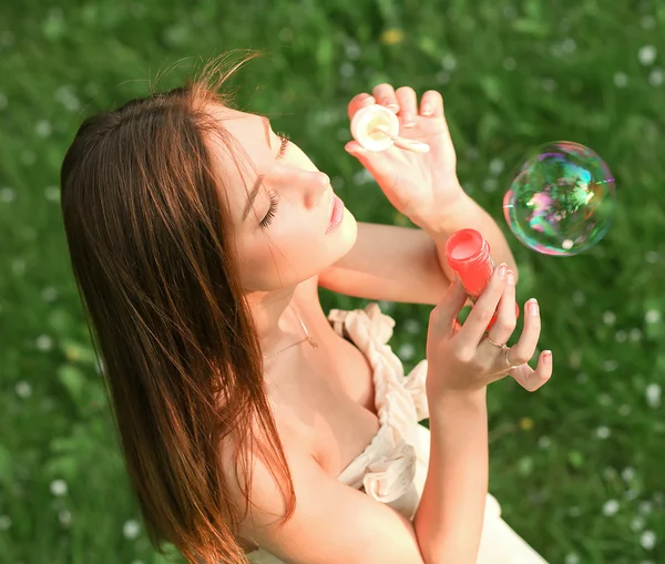 Giovane ragazza che soffia bolle di sapone nel parco verde estivo — Foto Stock