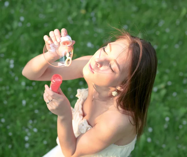 Fiatal lány buborékokat eregetett szappan, nyári zöld parkban — Stock Fotó