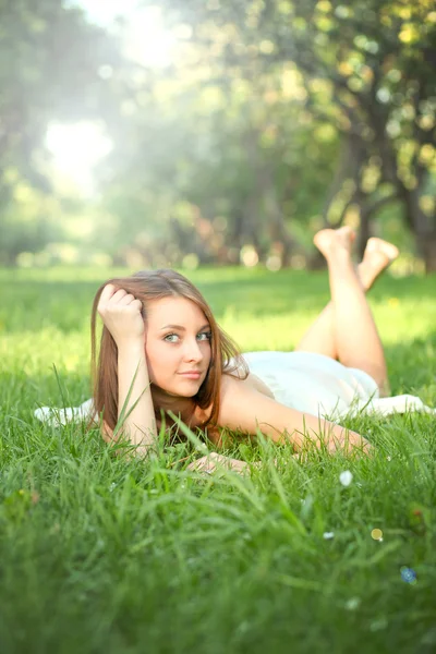 Retrato de una hermosa mujer joven relajándose en el parque de primavera —  Fotos de Stock