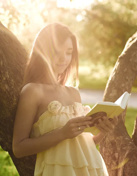 Muotokuva houkutteleva nuori tyttö käsittelyssä kirja kauniissa auringonpaisteessa — kuvapankkivalokuva