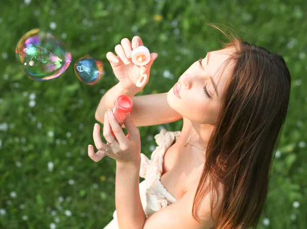 Привлекательная молодая девушка с мыльными пузырями — стоковое фото