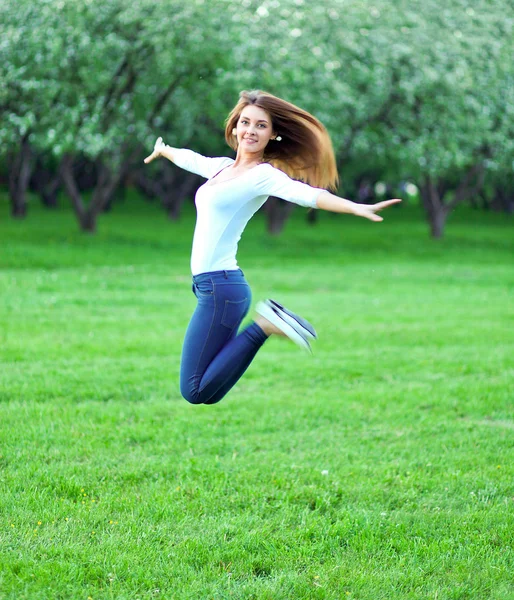 Saltando chica bonita con las manos abiertas en primavera parque rural —  Fotos de Stock