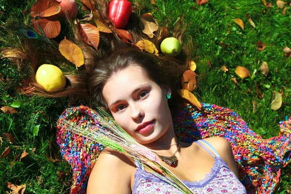 Mooi meisje liegen met groenten — Stockfoto