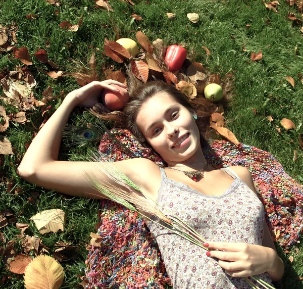 Симпатичная девушка, лежащая с овощами — стоковое фото