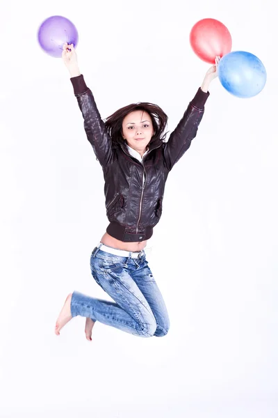 Beautiful pretty girl jumping with colorful balls — Stock Photo, Image