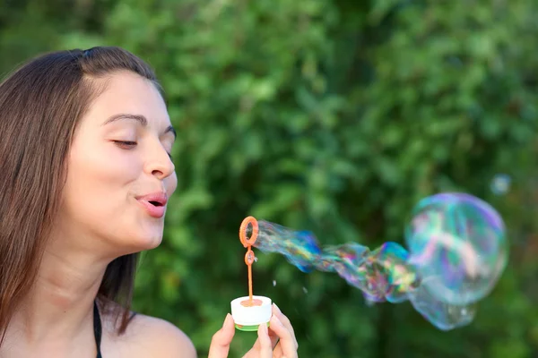 Ritratto di attraente ragazza gonfiare colorate bolle di sapone all'aperto — Foto Stock